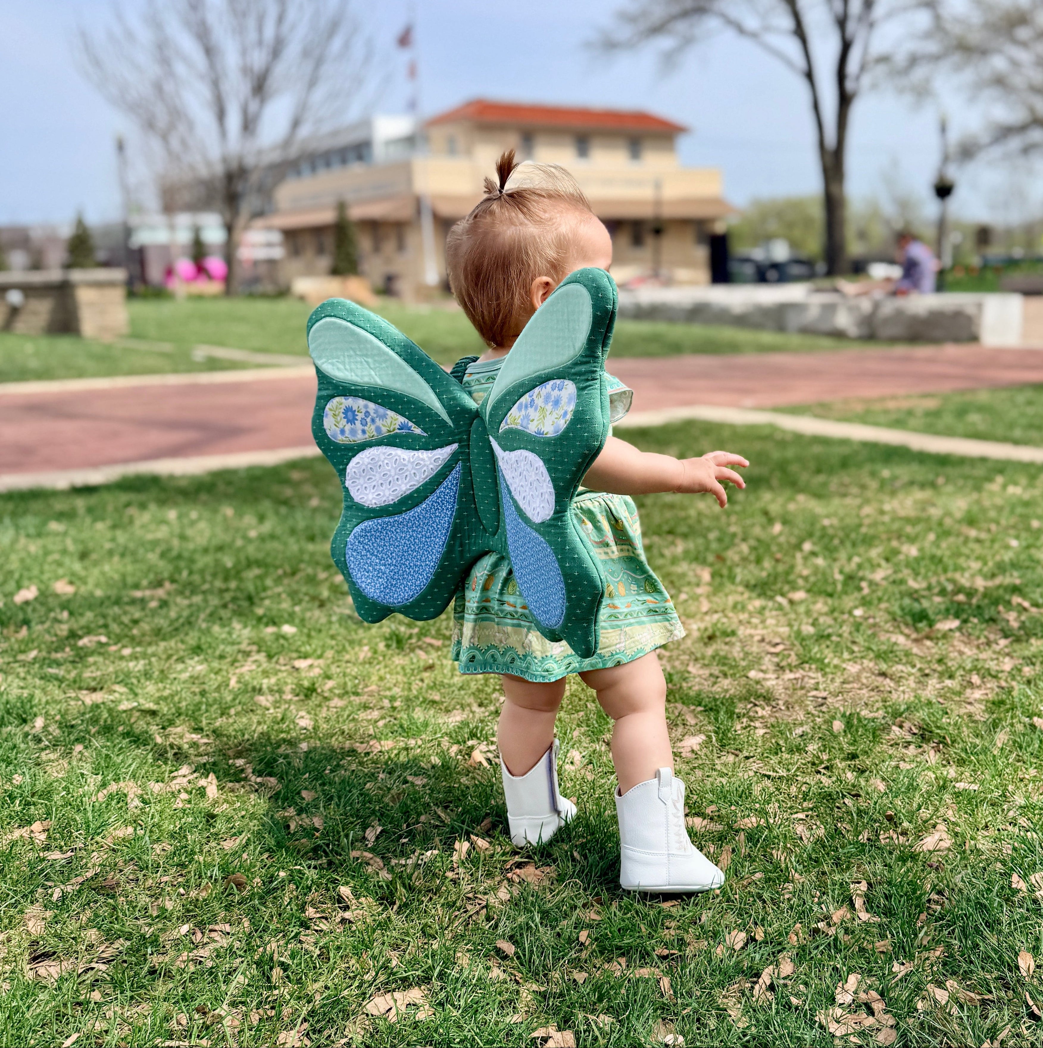 Child wearing butterfly wings in a park