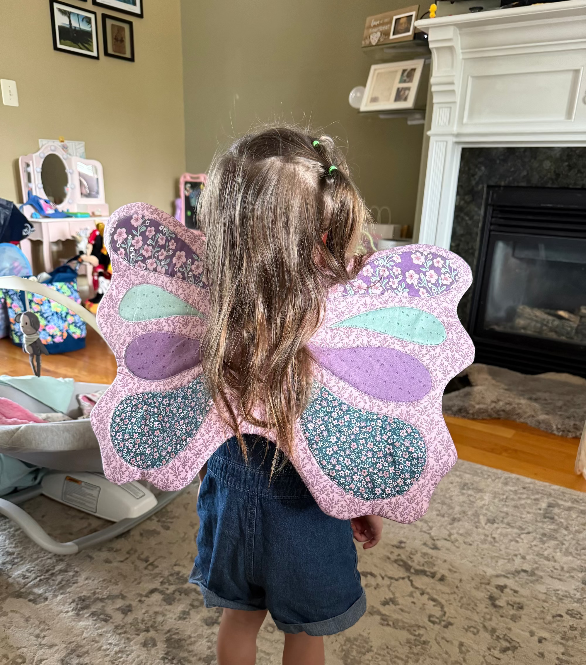 Child wearing butterfly wings in a living room