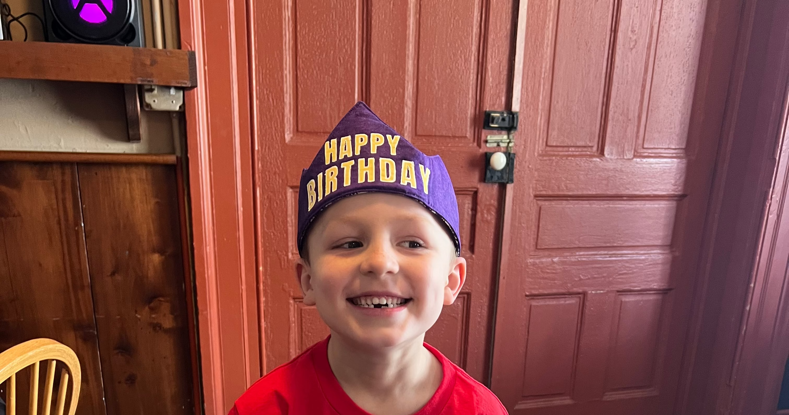 Child wearing a 'Happy Birthday' crown.